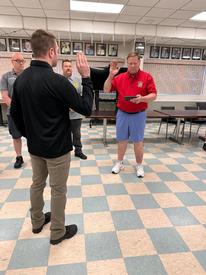 Commissioner Jim Albrecht swears in Marcus Macrillo as a career firefighter in the Pleasant Valley Fire District. 
